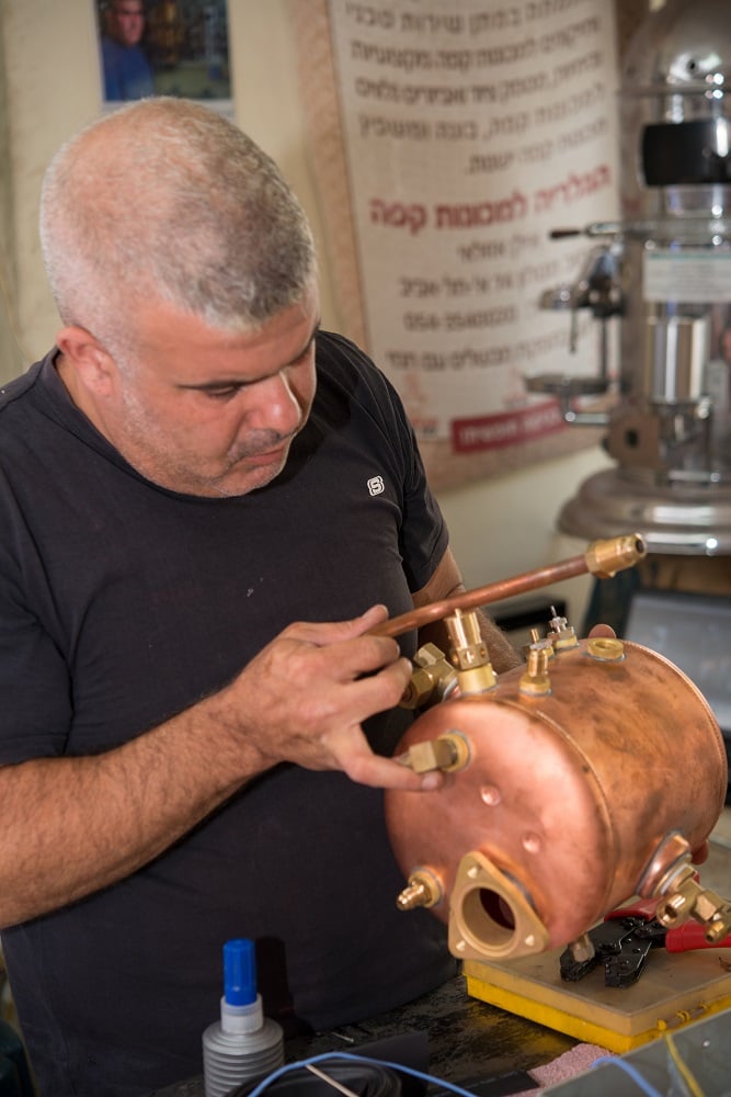 אילן בעבודה על מכונת אספרסו