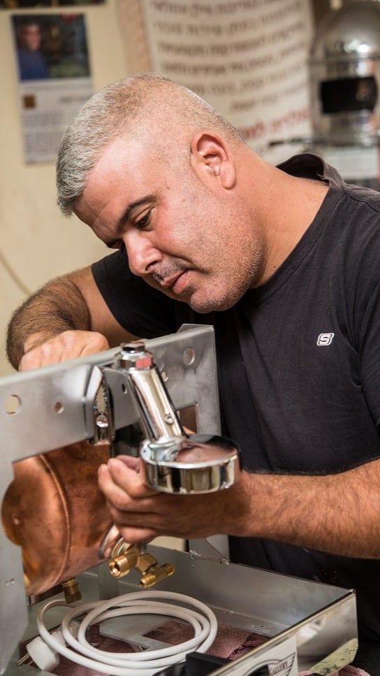 אילן בעבודה במעבדת התיקונים